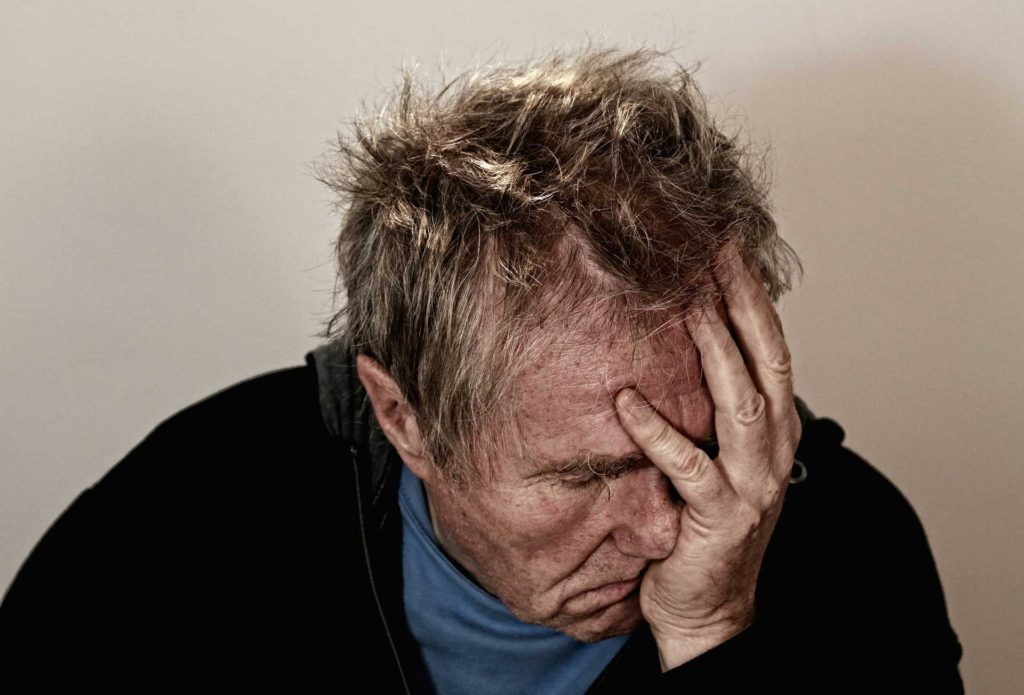 man-with-a-headache-migraine-holding-head-with-hands