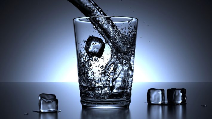 water pouring into a glass with ice