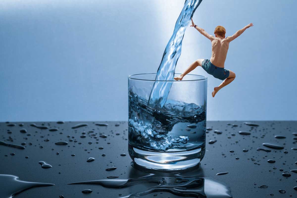 boy jumping in water glass
