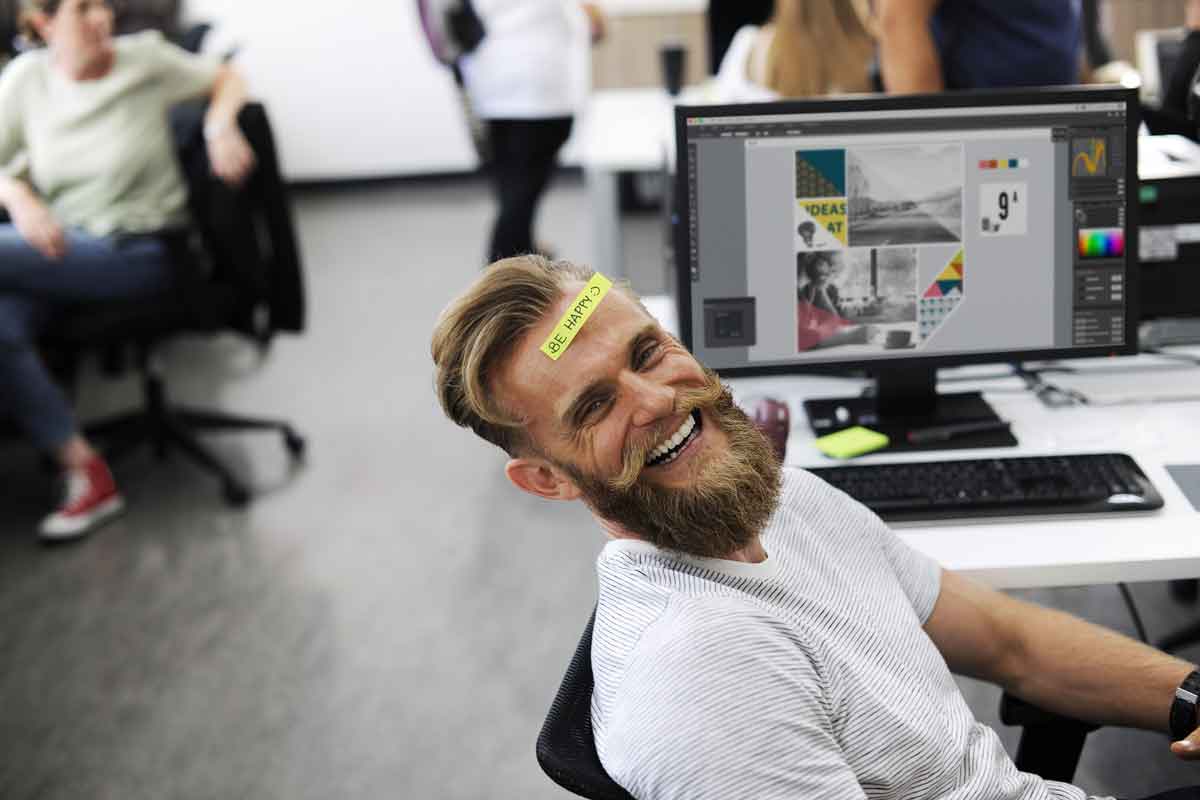 man laughing by his computer