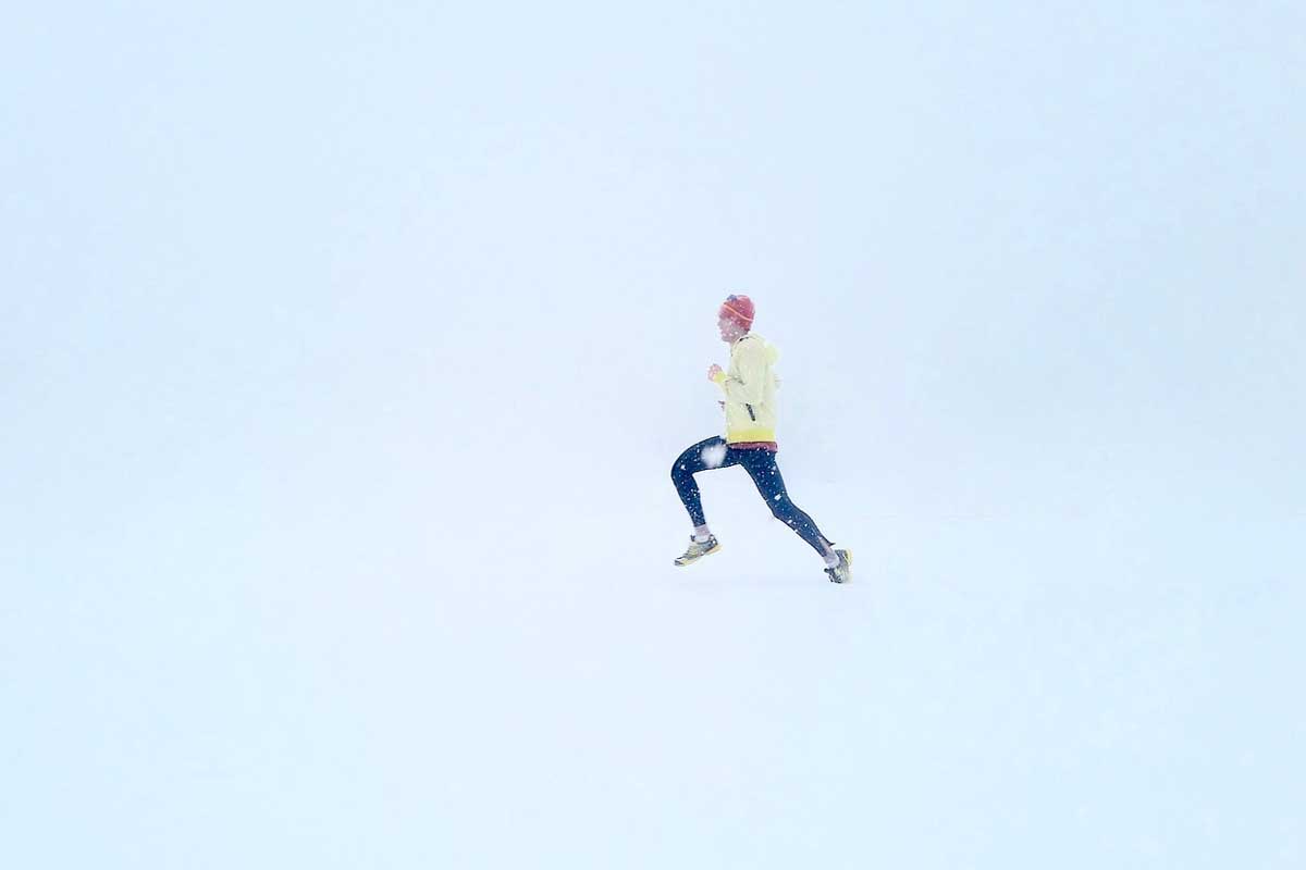 man running in the winter snow