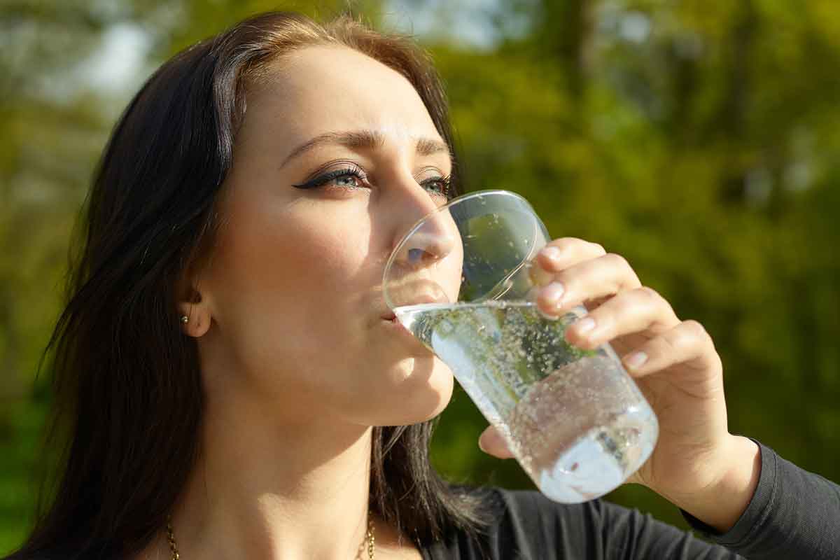 woman drinking sparkling water outside
