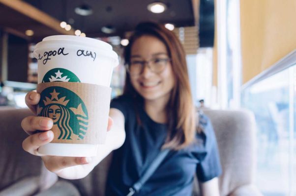 girl holding a starbucks coffee