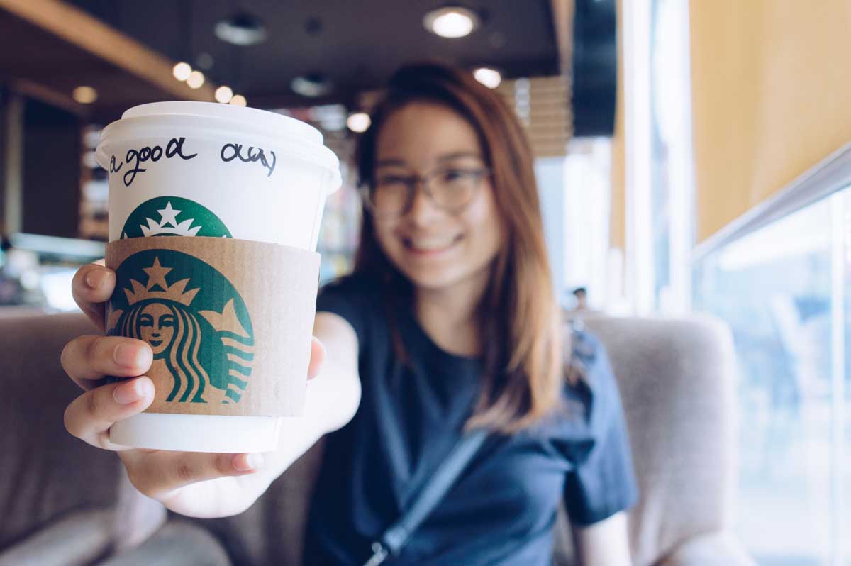 girl holding a starbucks coffee