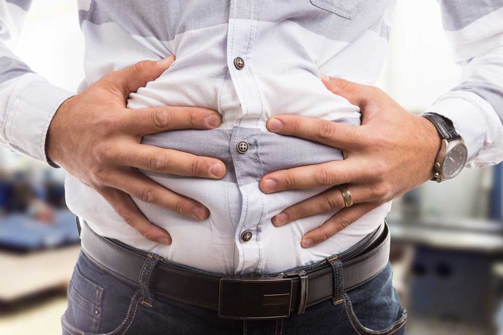 man holding his bloated belly