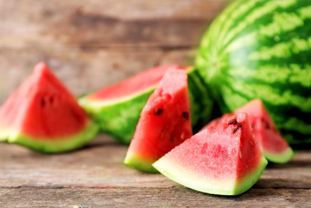 sliced up watermelon on wood table